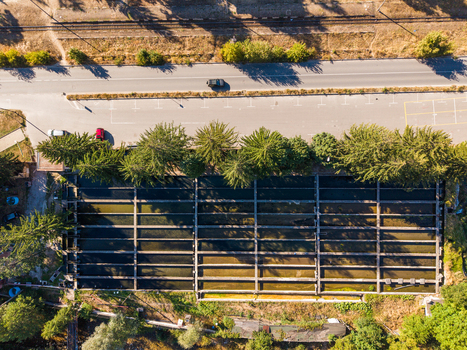 Aerial view of a fish farm with rectangular concrete ponds surrounded by lush green trees and adjacent to a road and railway tracks in Velingrad Pazardzhik Bulgaria. Aerial view of a fish farm with rectangular concrete ponds surrounded by lush green trees and adjacent to a road and railway tracks in Velingrad Pazardzhik Bulgaria.