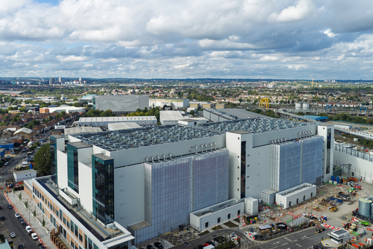 Aerial view of a large modern data center facility with extensive rooftop cooling units and industrial architecture situated in an urban environment in the United Kingdom. Aerial view of a large modern data center facility with extensive rooftop cooling units and industrial architecture situated in an urban environment in the United Kingdom.