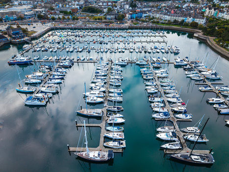 Aerial view of Bangor Harbour and Town featuring numerous sailboats and yachts docked in the marina surrounded by coastal buildings in Bangor Northern Ireland United Kingdom.