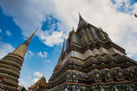 View of the ornate stupas at Wat Phra Chetuphon Wimon Mangkhalaram Rajwaramahawihan against a blue sky in Krung Thep Maha Nakho Thailand. View of the ornate stupas at Wat Phra Chetuphon Wimon Mangkhalaram Rajwaramahawihan against a blue sky in Krung Thep Maha Nakho Thailand.