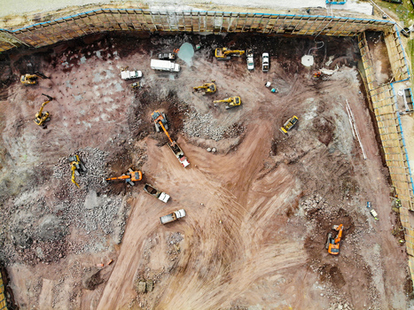 Reston Virginia United States 12 March 2019 Aerial view of a construction site with excavators dump trucks and piles of earth within a fenced excavation area. Reston Virginia United States 12 March 2019 Aerial view of a construction site with excavators dump trucks and piles of earth within a fenced excavation area.
