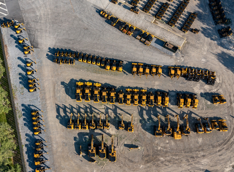 Aerial view of rows of yellow construction machinery and excavators parked in a large storage yard near Noxon Road in LaGrange New York United States. Aerial view of rows of yellow construction machinery and excavators parked in a large storage yard near Noxon Road in LaGrange New York United States.