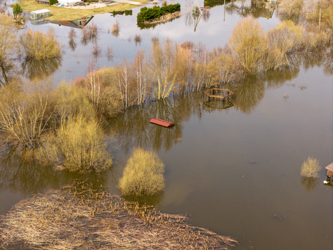 Aerial view of flooded fields and submerged trees reflecting in the water during a spring flood in Kedainiai Kaunas County Lithuania. Aerial view of flooded fields and submerged trees reflecting in the water during a spring flood in Kedainiai Kaunas County Lithuania.