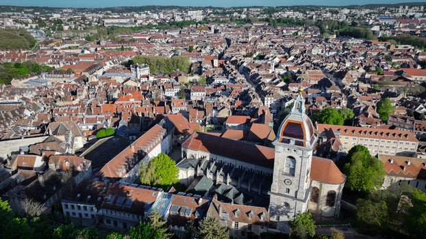 Aerial view of the Cathedrale Saint Jean and the historic red tiled rooftops of the old town under a clear blue sky in Besancon Bourgogne Franche Comte France. Aerial view of the Cathedrale Saint Jean and the historic red tiled rooftops of the old town under a clear blue sky in Besancon Bourgogne Franche Comte France.