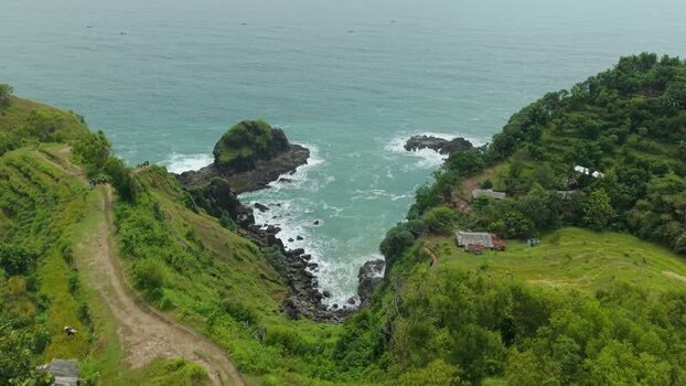Aerial view of Banyutibo Waterfall and coastal cliffs Indonesia.
