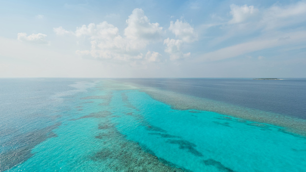 Aerial view of the turquoise sea with coral reefs shimmering beneath the surface contrasting with the deep blue of the open ocean Malé Malé Maldives. Aerial view of the turquoise sea with coral reefs shimmering beneath the surface contrasting with the deep blue of the open ocean Malé Malé Maldives.