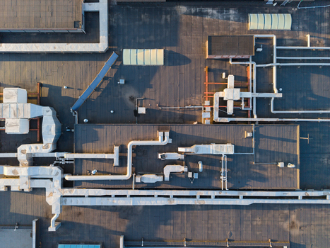 Aerial view of industrial rooftop with complex HVAC ductwork ventilation pipes and air conditioning units on a flat roof surface in Hasselt Flanders Belgium. Aerial view of industrial rooftop with complex HVAC ductwork ventilation pipes and air conditioning units on a flat roof surface in Hasselt Flanders Belgium.