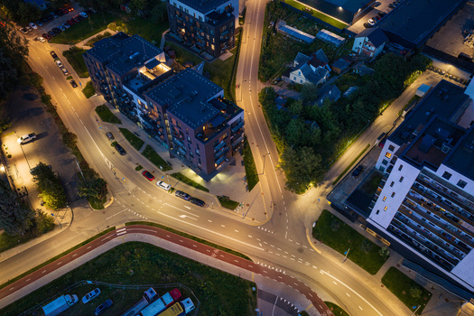 Aerial view of a modern urban intersection at night with contemporary apartment buildings illuminated streets and a bicycle path in Vilnius Vilnius County Lithuania. Aerial view of a modern urban intersection at night with contemporary apartment buildings illuminated streets and a bicycle path in Vilnius Vilnius County Lithuania.