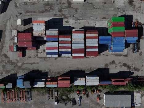 Aerial view of stacked colorful shipping containers in an industrial freight yard with asphalt ground Cincinnati OH United States.