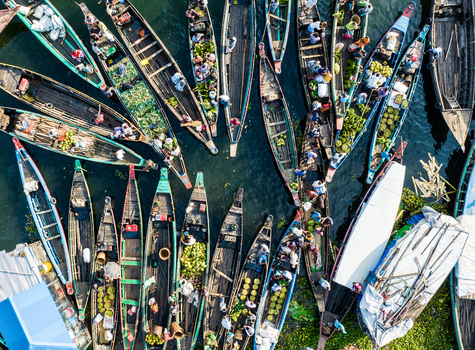 Rangamati Bangladesh 19 October 2022 Aerial view of traditional wooden boats laden with produce in the waterways of Rangamati featuring vibrant colors and busy market activity.