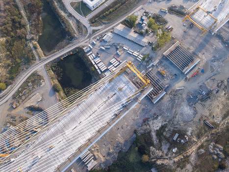 Aerial view of a cable stayed bridge under construction with concrete segments steel cables and heavy machinery on the surrounding site in Istanbul Istanbul Turkiye.