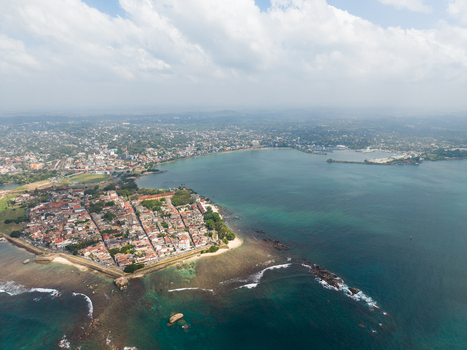 Aerial view of Galle Fort on a peninsula surrounded by turquoise ocean waters and coral reefs under a cloudy sky Galle Southern Province Sri Lanka. Aerial view of Galle Fort on a peninsula surrounded by turquoise ocean waters and coral reefs under a cloudy sky Galle Southern Province Sri Lanka.