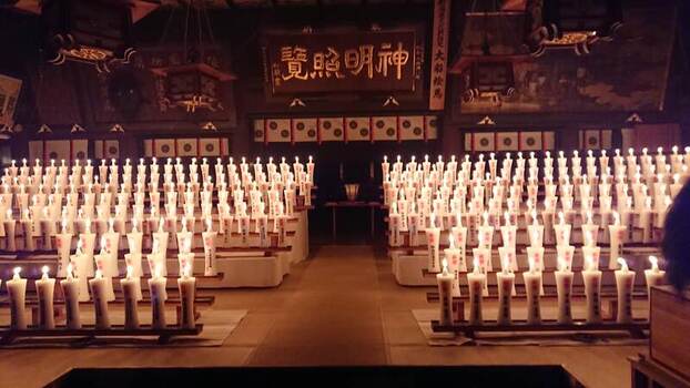 View of the interior of Hakusan Shrine illuminated by rows of glowing candles in Niigata Niigata Japan.
