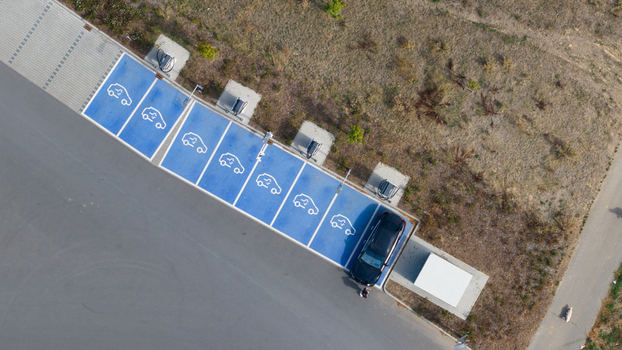 Aerial view of an electric vehicle charging station with blue painted parking spots and charging infrastructure in Liederbach am Taunus Hessen Germany.