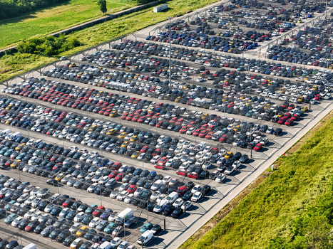 Aerial view of a massive parking lot filled with rows of colorful cars and vehicles next to green fields in Rivalta di Torino Piedmont Italy. Aerial view of a massive parking lot filled with rows of colorful cars and vehicles next to green fields in Rivalta di Torino Piedmont Italy.