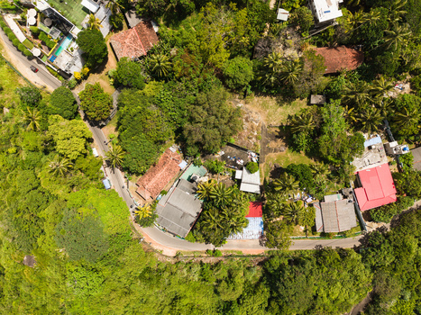 Aerial view of the area near Jungle Beach featuring lush tropical vegetation and residential houses with tiled roofs in Unawatuna Sri Lanka. Aerial view of the area near Jungle Beach featuring lush tropical vegetation and residential houses with tiled roofs in Unawatuna Sri Lanka.