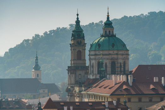 View of the historic St. Nicholas Church with its prominent green dome and clock tower rising above the terracotta rooftops of the city Prague Prague Czechia.
