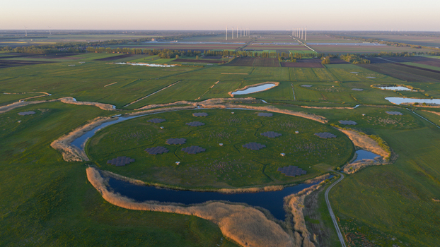 Aerial view of the LOFAR superterp radio telescope core with antenna arrays on a circular mound surrounded by water and green fields in Buinen Drenthe Netherlands. Aerial view of the LOFAR superterp radio telescope core with antenna arrays on a circular mound surrounded by water and green fields in Buinen Drenthe Netherlands.