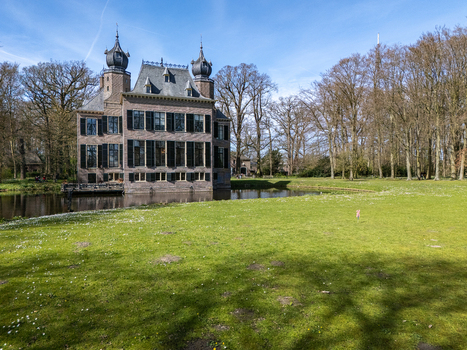 Aerial view of the stately Landgoed Oud Poelgeest castle mirroring in the moat embraced by green lawns and bare trees Oegstgeest Zuid Holland Netherlands. Aerial view of the stately Landgoed Oud Poelgeest castle mirroring in the moat embraced by green lawns and bare trees Oegstgeest Zuid Holland Netherlands.