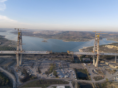 Aerial view of the Yavuz Sultan Selim Bridge under construction featuring tall concrete pylons steel cables and a wide span over the water in Istanbul Istanbul Turkiye.