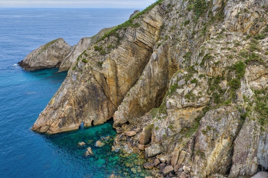 Aerial view of the rugged cliffs of Silence Beach Viewpoint with turquoise water and rocky shoreline in Cudillero Asturias Spain.