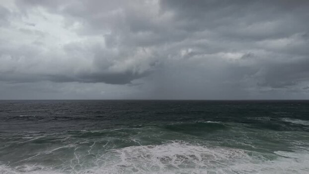 Aerial view of dark ocean water under cloudy sky Australia.