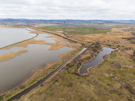 Aerial view of Lake Atanasovsko featuring narrow canals and golden reeds under a cloudy sky in Burgas Burgas Bulgaria. Aerial view of Lake Atanasovsko featuring narrow canals and golden reeds under a cloudy sky in Burgas Burgas Bulgaria.