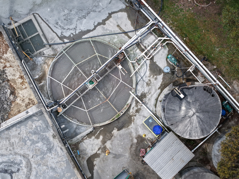 Aerial view of an industrial water treatment facility featuring large circular tanks complex piping networks and concrete infrastructure in Melbourne VIC Australia.