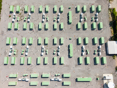 Aerial view of a modern battery energy storage system with rows of green containers and power equipment on a gravel site in Tavazzano con Villavesco Lombardy Italy.