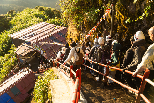 View of pilgrims climbing the steep stone stairs of Adam s Peak surrounded by prayer flags and lush mountain vegetation Ratnapura Sabaragamuwa Province Sri Lanka. View of pilgrims climbing the steep stone stairs of Adam s Peak surrounded by prayer flags and lush mountain vegetation Ratnapura Sabaragamuwa Province Sri Lanka.