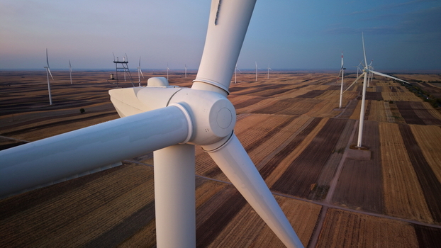Aerial view of wind turbines in a vast agricultural field during golden hour in Vladimirovac Vojvodina Serbia. Aerial view of wind turbines in a vast agricultural field during golden hour in Vladimirovac Vojvodina Serbia.