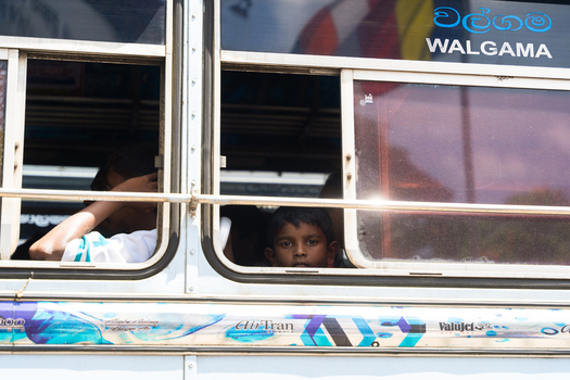 Sri Lanka 19 February 2026 View of a young boy looking out of the window of a public bus labeled Walgama with other passengers visible inside.