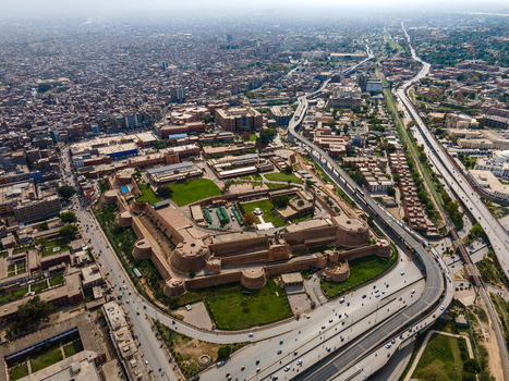Aerial view of Bala Hisar Fort with its historic fortifications and green courtyards surrounded by the dense urban sprawl and highway of Peshawar Khyber Pakhtunkhwa Pakistan.