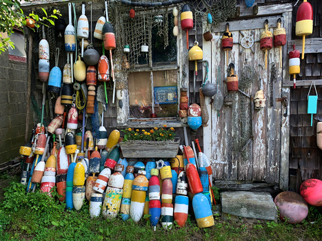 View of a rustic wooden fishing shack adorned with a vibrant collection of colorful buoys and nautical nets in Edgartown Massachusetts United States.