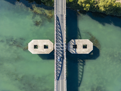 Aerial view of Ura e re e Bunes crossing the turquoise waters of the Buna River with concrete piers casting long shadows in Shkoder Qarku i Shkodres Albania. Aerial view of Ura e re e Bunes crossing the turquoise waters of the Buna River with concrete piers casting long shadows in Shkoder Qarku i Shkodres Albania.