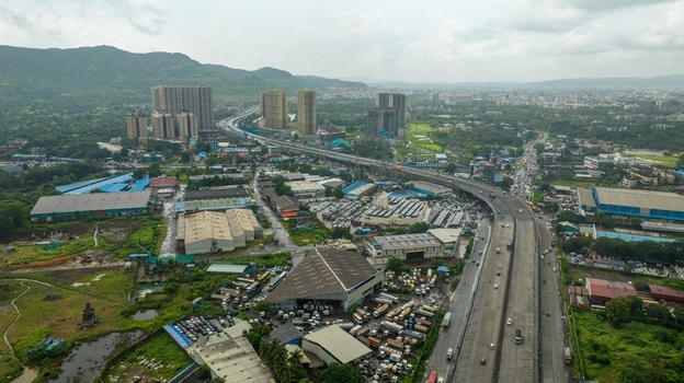 Aerial view of the JNPT Interchange in Navi Mumbai featuring a complex highway network industrial warehouses and high rise buildings Navi Mumbai Maharashtra India. Aerial view of the JNPT Interchange in Navi Mumbai featuring a complex highway network industrial warehouses and high rise buildings Navi Mumbai Maharashtra India.