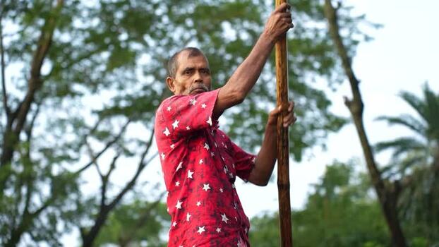 View of a man punting a boat with a bamboo pole Bangladesh. View of a man punting a boat with a bamboo pole Bangladesh.
