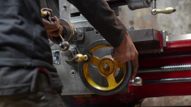 View of a worker operating a manual lathe machine in Bangladesh.