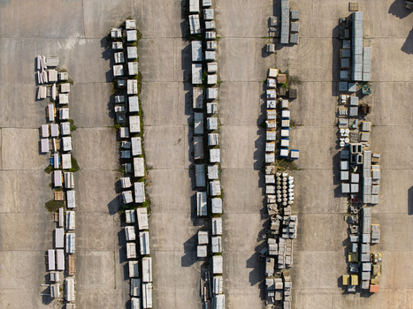 Aerial view of stacked concrete blocks and construction materials in rows in an industrial yard with long shadows in Lisburn Northern Ireland United Kingdom. Aerial view of stacked concrete blocks and construction materials in rows in an industrial yard with long shadows in Lisburn Northern Ireland United Kingdom.