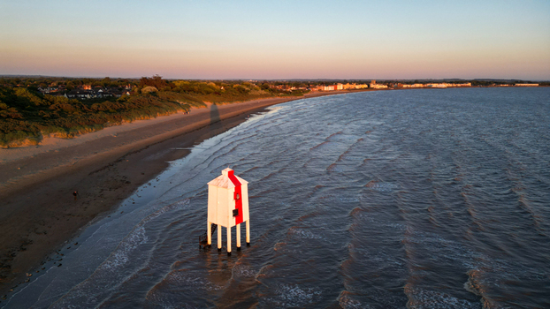 Aerial view of the iconic Burnham on Sea Low Lighthouse standing in the tide at sunset with the sandy beach coastal town and calm sea waves in Burnham on Sea England United Kingdom. Aerial view of the iconic Burnham on Sea Low Lighthouse standing in the tide at sunset with the sandy beach coastal town and calm sea waves in Burnham on Sea England United Kingdom.