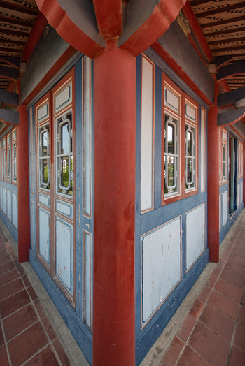 View of the ornate red and blue wooden architecture of Chihkan Tower with traditional windows and tiled flooring in Chihkan Village Tainan City Taiwan. View of the ornate red and blue wooden architecture of Chihkan Tower with traditional windows and tiled flooring in Chihkan Village Tainan City Taiwan.
