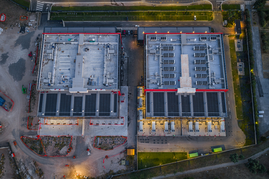 Aerial view of a modern datacenter facility featuring rooftop HVAC units solar panels and surrounding infrastructure in Settecamini Lazio Italy.