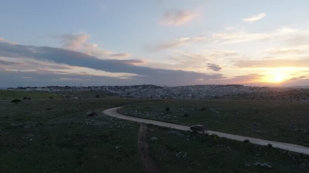 Aerial view of Matera at sunset with a winding road Italy.