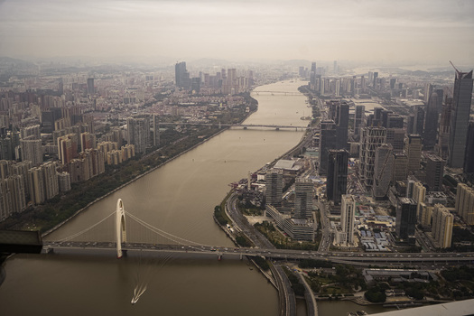 Aerial view of the Liede Bridge spanning the Pearl River with modern skyscrapers and urban development in Guangzhou Guangdong Province China. Aerial view of the Liede Bridge spanning the Pearl River with modern skyscrapers and urban development in Guangzhou Guangdong Province China.