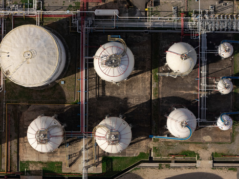 Aerial view of industrial storage tanks and complex piping systems at a refinery in Bajos de Haina San Cristobal Province Dominican Republic.