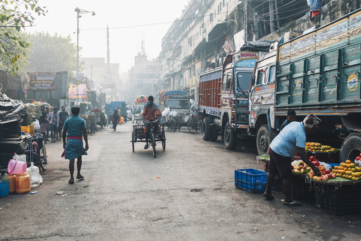 Kolkata India 05 December 2024 View of the bustling street scene where vibrant colors of fruits contrast with the muted tones of trucks and buildings. Kolkata India 05 December 2024 View of the bustling street scene where vibrant colors of fruits contrast with the muted tones of trucks and buildings.