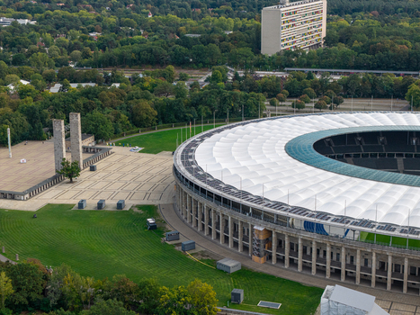 Berlin Germany 26 September 2026 Aerial view of Olympiastadion Berlin showing its iconic roof structure surrounding green parkland and historic stone pillars.