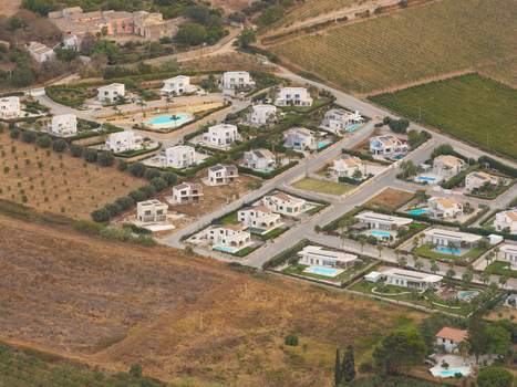 Aerial view of a modern residential complex with white villas private swimming pools and landscaped gardens situated in the countryside near San Vito Lo Capo Sicilia Italy. Aerial view of a modern residential complex with white villas private swimming pools and landscaped gardens situated in the countryside near San Vito Lo Capo Sicilia Italy.