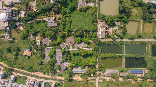 Aerial view of a fishing farm with rectangular ponds lush green trees and surrounding buildings in Punjab Pakistan. Aerial view of a fishing farm with rectangular ponds lush green trees and surrounding buildings in Punjab Pakistan.