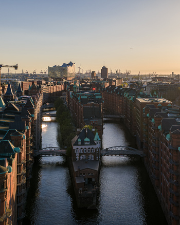 Aerial view of the historic Speicherstadt warehouse district with its red brick buildings and canals under a golden sunset in Hamburg Hamburg Germany. Aerial view of the historic Speicherstadt warehouse district with its red brick buildings and canals under a golden sunset in Hamburg Hamburg Germany.